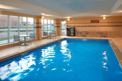 大急流城TownePlace Suites by Marriott Grand Rapids Airport的酒店的大型游泳池配有桌椅