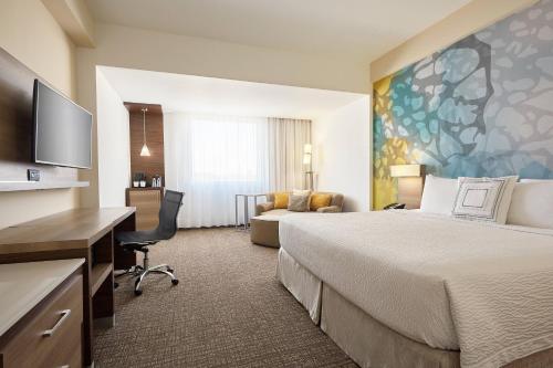 埃莫西约埃莫西万豪万怡酒店的酒店客房设有一张大床和一张书桌。