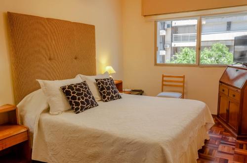蒙得维的亚Apartamento en el centro de Pocitos的卧室配有带枕头的床铺和窗户。
