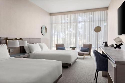森尼维耳市TETRA Hotel, Autograph Collection的酒店客房配有两张床和一张书桌