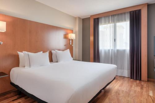 塞维利亚AC Hotel Sevilla Fórum by Marriott的窗户客房内的一张大白色床
