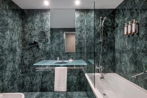 塞维利亚AC Hotel Sevilla Fórum by Marriott的一间带水槽、浴缸和淋浴的浴室
