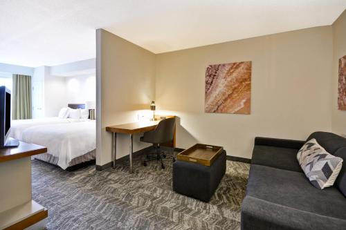 列克星敦列克星敦肯塔基大学附近春季山丘套房酒店的配有一张床和一张书桌的酒店客房