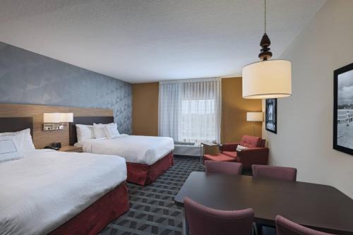 那不勒斯TownePlace Suites by Marriott Naples的酒店客房设有两张床和一张桌子。
