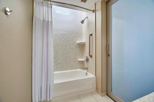 拉斯维加斯SpringHill Suites by Marriott Las Vegas Convention Center的带浴缸和淋浴帘的浴室