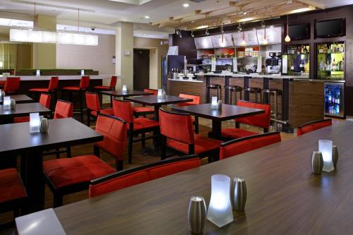 阿尔图纳阿尔图纳万怡酒店的一间带桌椅的餐厅和一间酒吧