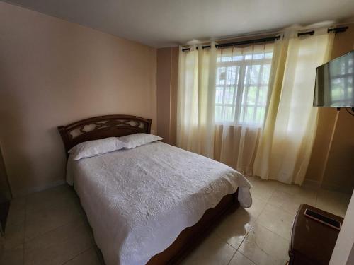 布加Apartamento completo en el sur de Buga的一间卧室设有一张床和一个窗口