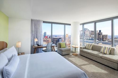 费城Element Philadelphia Downtown的一间卧室配有一张床、一张沙发和窗户。