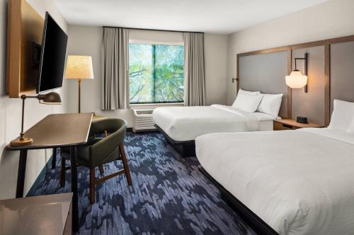 德卢斯Fairfield by Marriott Inn & Suites Duluth的酒店客房配有两张床和一张书桌