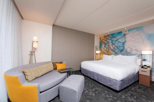 霍兰霍兰市中心万怡酒店的酒店客房,配有床和沙发