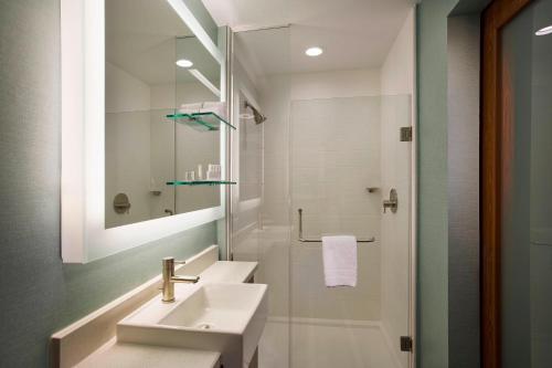 休斯顿休斯顿闹市区万豪春季山丘套房酒店/会议中心的白色的浴室设有水槽和淋浴。