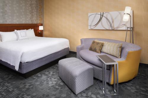 列克星敦列克星敦北万怡酒店的配有一张床和一把椅子的酒店客房