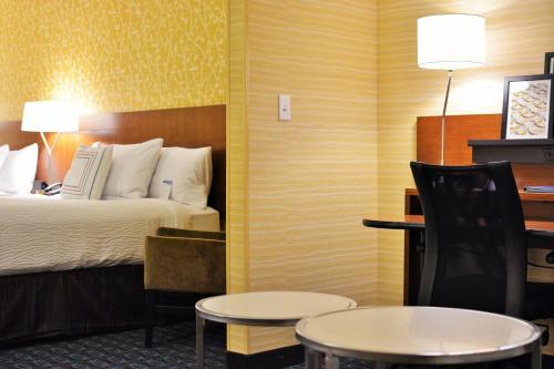 奥马哈奥马哈西北万豪费尔菲尔德酒店的酒店客房带一张床、一张桌子和椅子
