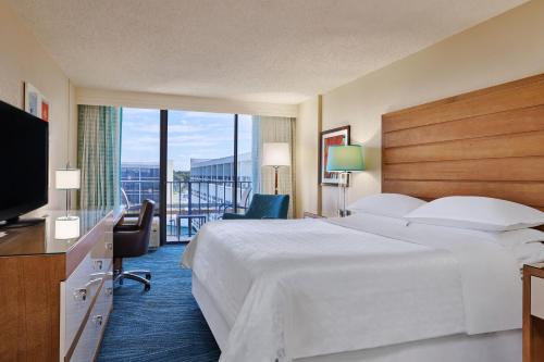 奥兰多Sheraton Orlando Lake Buena Vista Resort的酒店客房设有一张大床和一台电视。