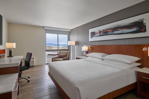 威斯敏斯特Delta Hotels by Marriott Denver Thornton的酒店客房设有一张大床和一张书桌。