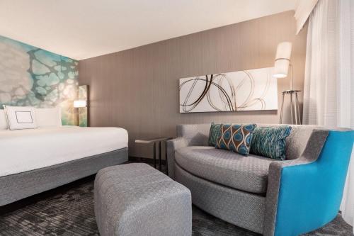 托皮卡托皮卡万怡酒店的配有一张床和一把椅子的酒店客房