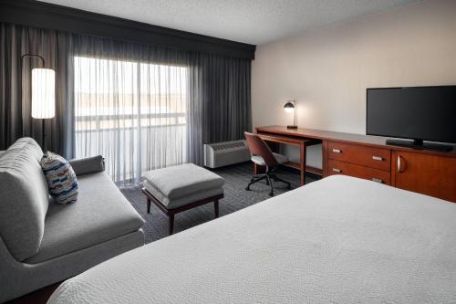 塔奇拉西雅图中南部万怡酒店的酒店客房配有一张床、一张书桌和一台电视。