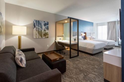 梅普尔格罗夫SpringHill Suites Minneapolis Maple Grove/Arbor Lakes的酒店客房设有一张沙发和一张床
