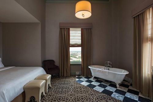 休斯顿阿尔冈昆签名典藏酒店的酒店客房配有一张床和浴缸。