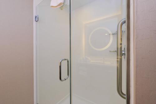 达拉姆春季山丘套房达勒姆教堂山酒店的浴室内带镜子的玻璃淋浴间门