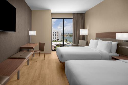 克利尔沃特AC Hotel by Marriott Clearwater Beach的酒店客房设有两张床和电视。