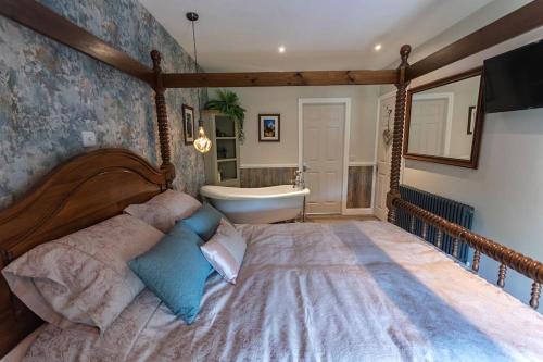 CranwellLuxury retreat in Lincolnshire with hot tub的一间卧室设有一张大床和一个浴缸