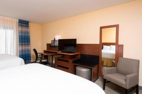 坦帕坦帕西岸/机场万豪费尔菲尔德客栈的酒店客房配有一张床和一张书桌及一台电视