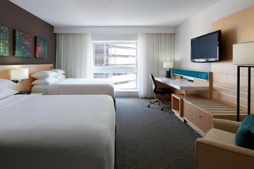 蒙特利尔蒙特利尔万豪德尔塔酒店的酒店客房设有两张床、一张桌子和一台电视。