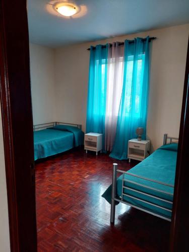 蓬他达维托亚Casa do Miradouro的一间卧室设有两张床和蓝色窗帘