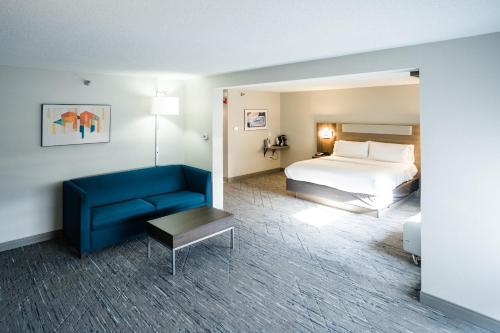 诺克斯维尔诺克斯维尔北I75州际公路12号出口智选假日酒店的酒店客房,配有床和蓝色的沙发