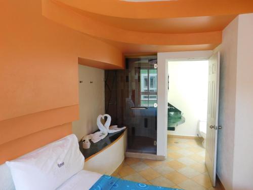 墨西哥城Hotel Extasis的一间卧室设有橙色天花板、一张床和一间卧室