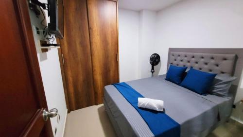 贝约ANDALIVING NIQUIA APARTAMENTO的一间卧室配有一张带蓝色床单和蓝色枕头的床。