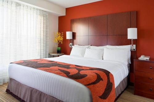 麦迪逊麦迪逊东原住客栈的酒店客房设有一张带橙色墙壁的大床