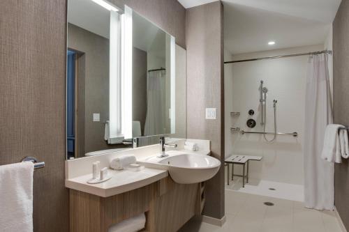 米拉玛SpringHill Suites by Marriott Fort Lauderdale Miramar的一间带水槽、镜子和淋浴的浴室