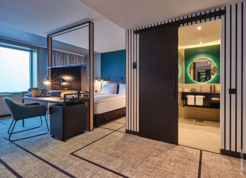 嘉兴贝慕尼黑Dorint Hotel München/Garching的酒店客房设有一间带一张床和一张书桌的卧室