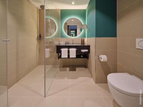 嘉兴贝慕尼黑Dorint Hotel München/Garching的一间带卫生间、水槽和镜子的浴室