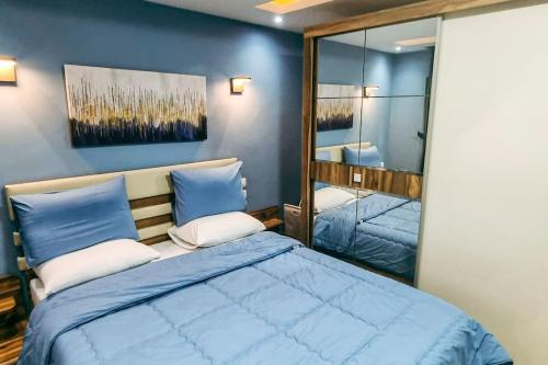 开罗Luxury VIP apartment的一间卧室配有一张大蓝色的床和镜子