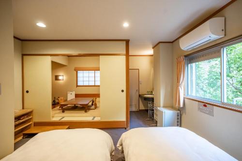 京丹后市昭恋馆予志日式旅馆的一间卧室配有两张床和镜子