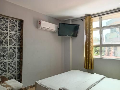 拉布安HOTEL RK CAHAYA的客房设有床、电视和窗户。