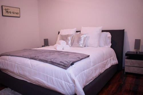 圣路易斯Cozy Stylish Downtown Loft的卧室配有一张带白色床单和枕头的大床。