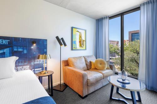 墨尔本Naima Hotel的酒店客房设有床、沙发和窗户。