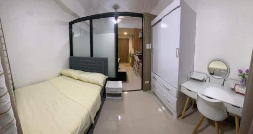 马尼拉Cozy 1Br with Netflix & Balcony Pool View Condo的一间带床和水槽的小卧室