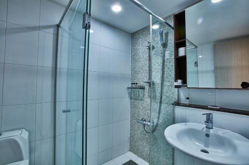 首尔Provista Hotel的一间带玻璃淋浴和水槽的浴室