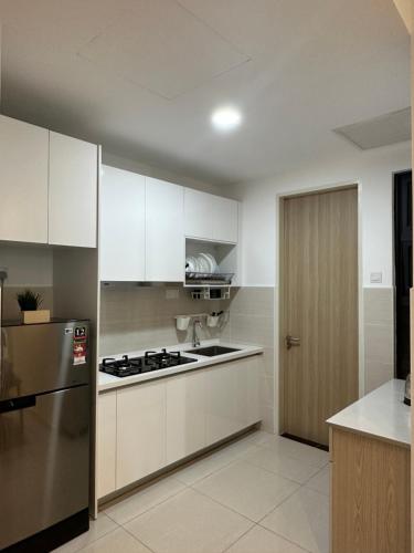 吉隆坡KLCC Kampung Baru Cottage - Homestay的厨房配有白色橱柜和不锈钢冰箱
