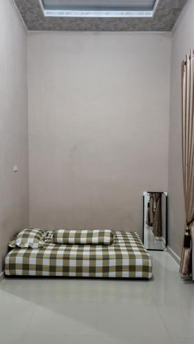 HalanganHomeStay Pandan Baru的白色客房的一张床铺,配有一张铺着 ⁇ 子的床垫