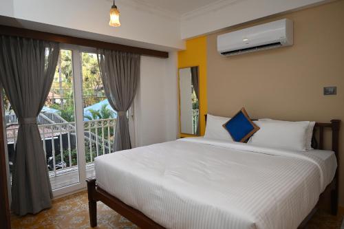 巴加Richmonde Ananta Elite Luxurious Villa & Apartments,Goa的一间卧室设有一张床和一个阳台