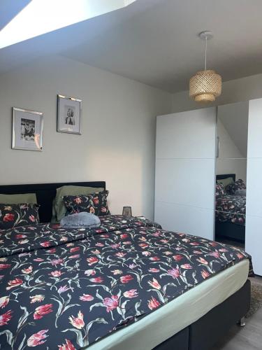 列日Le cocon de la belle liégeoise的一间卧室配有一张带花卉床罩的床