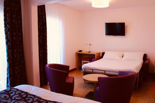 沙布利利斯夏布利酒店的一间设有两张床和一张桌子及椅子的房间
