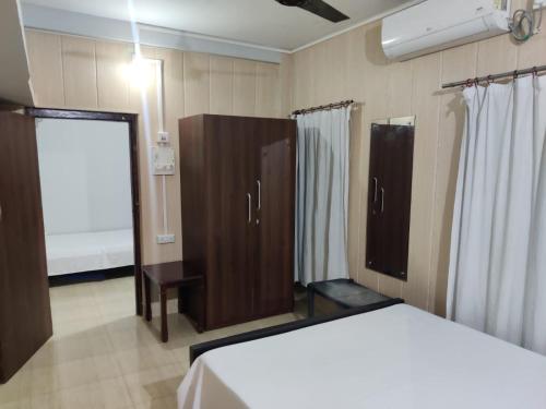 西里古里Newa Service Apartment的一间卧室配有床、橱柜和窗户