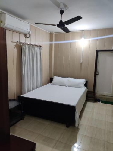西里古里Newa Service Apartment的一间卧室配有一张带吊扇的床